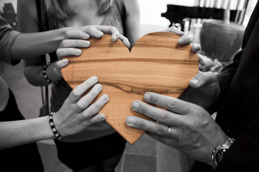 hands holding a wooden heart