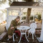 older woman writing in journal outside